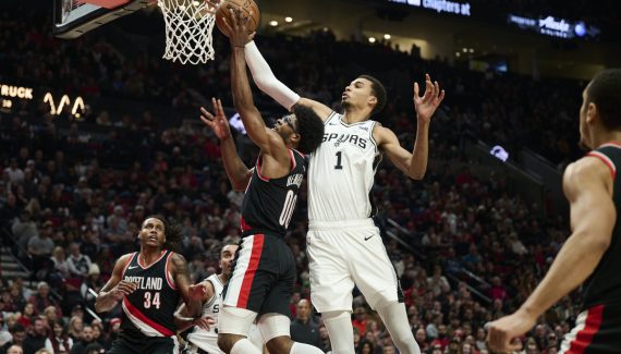 Scoot Henderson and Jrue Holiday approach the floor